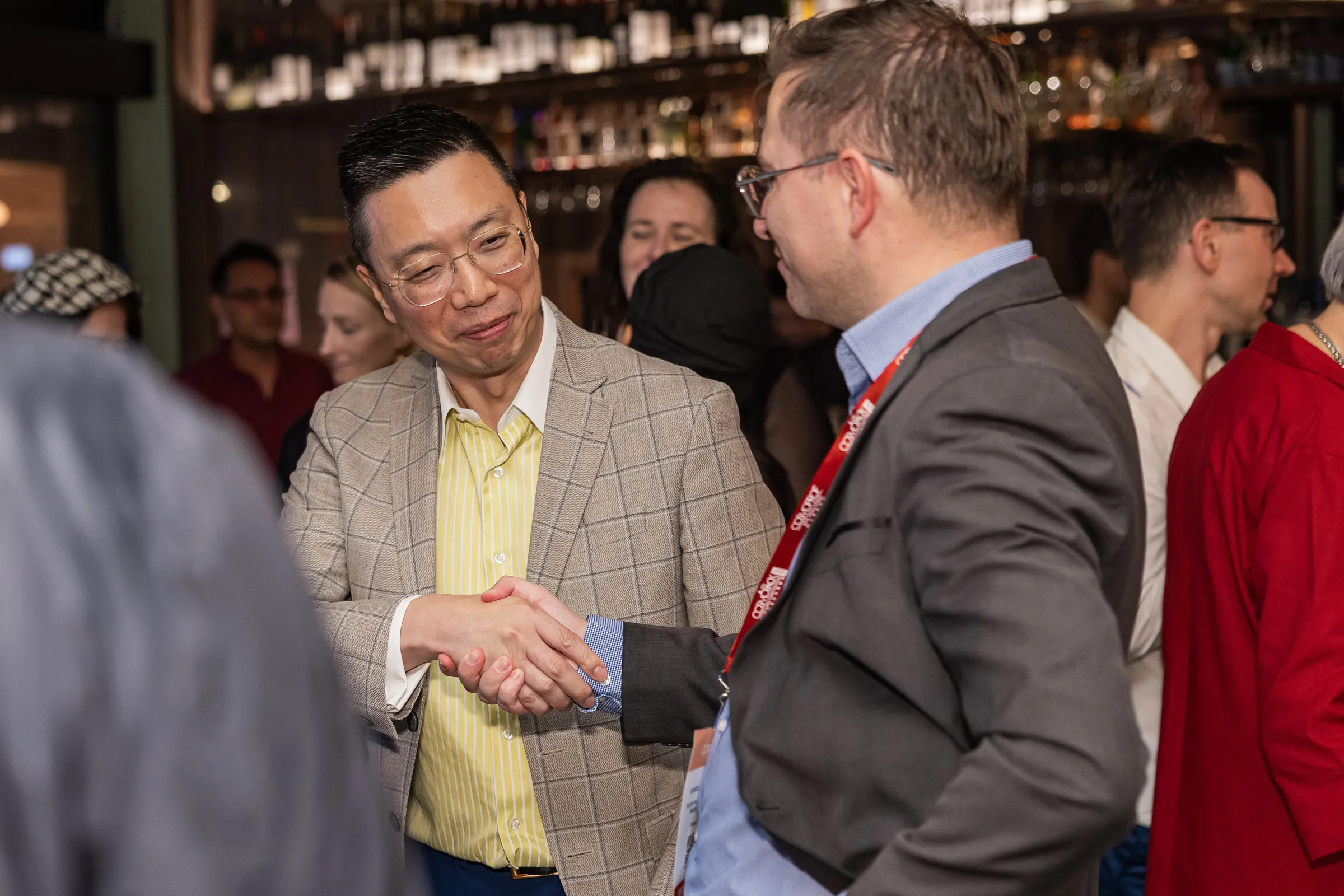 Two guests shaking hands at a club networking evening