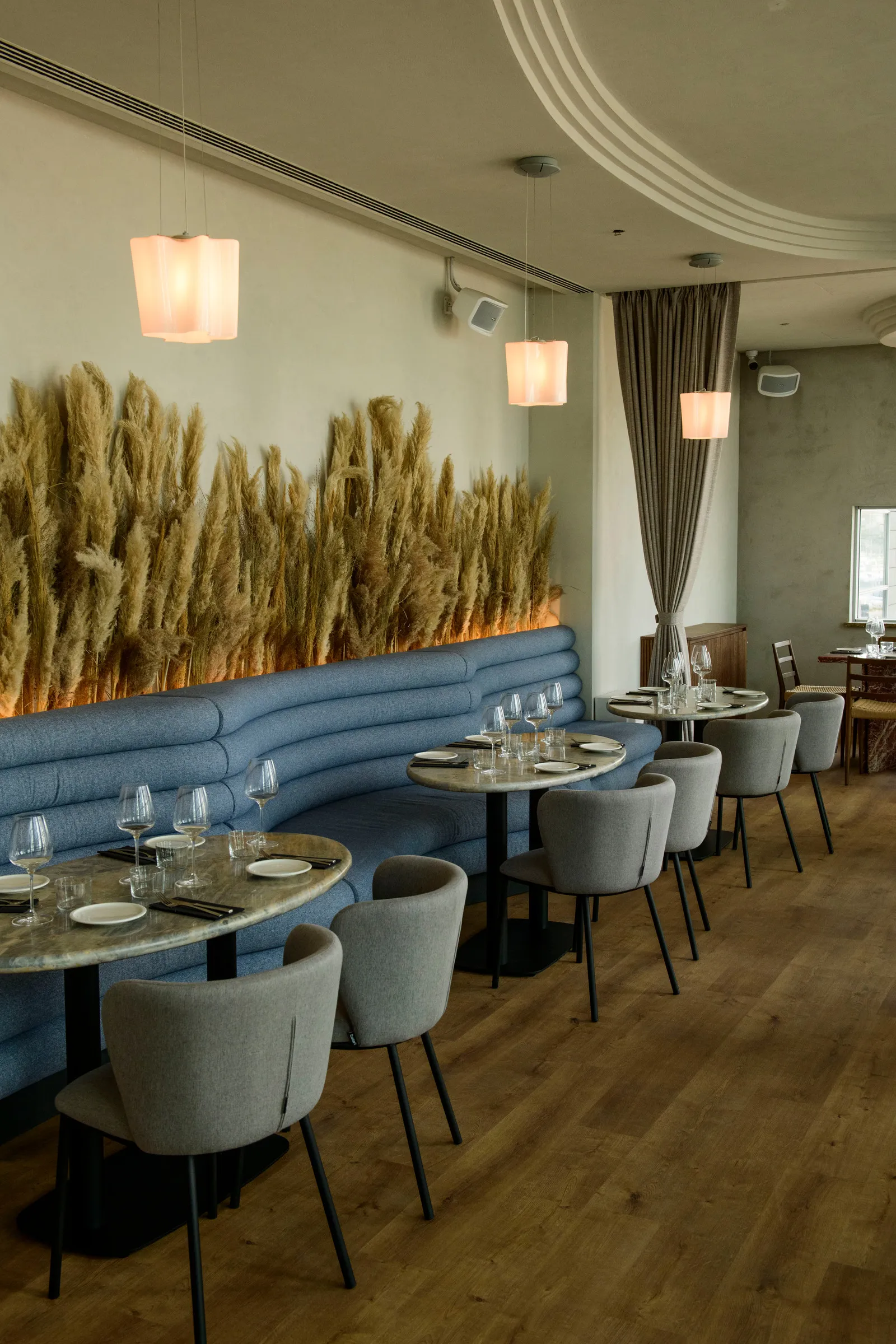 Upper floor dining room with blue banquettes and dried decorative grasses