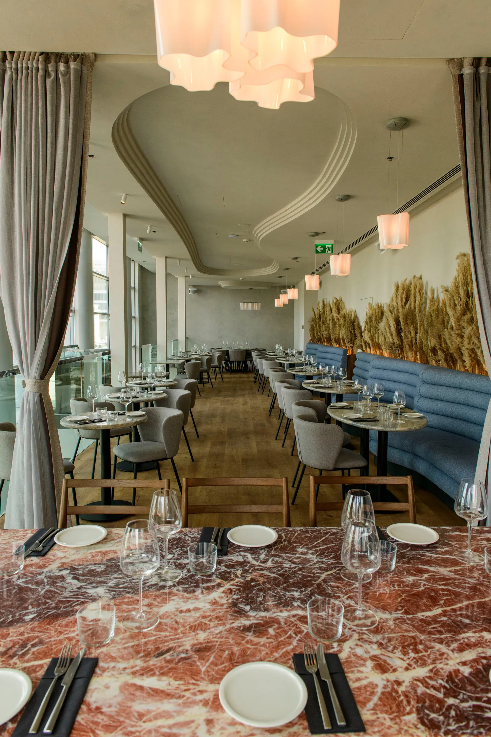 Red marble table in the foreground of the bright upper floor