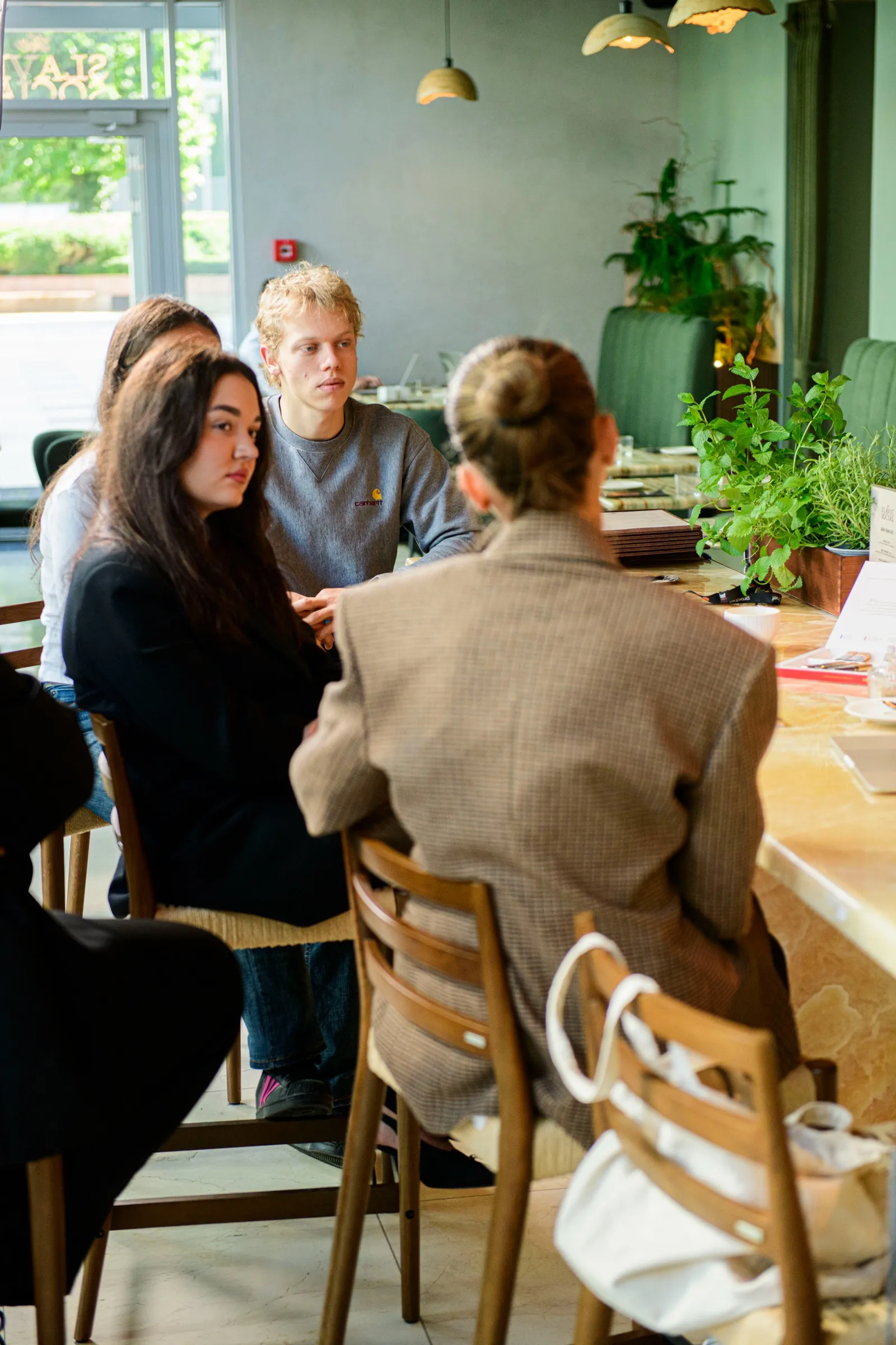 Goście rozmawiają przy stole w sali restauracji